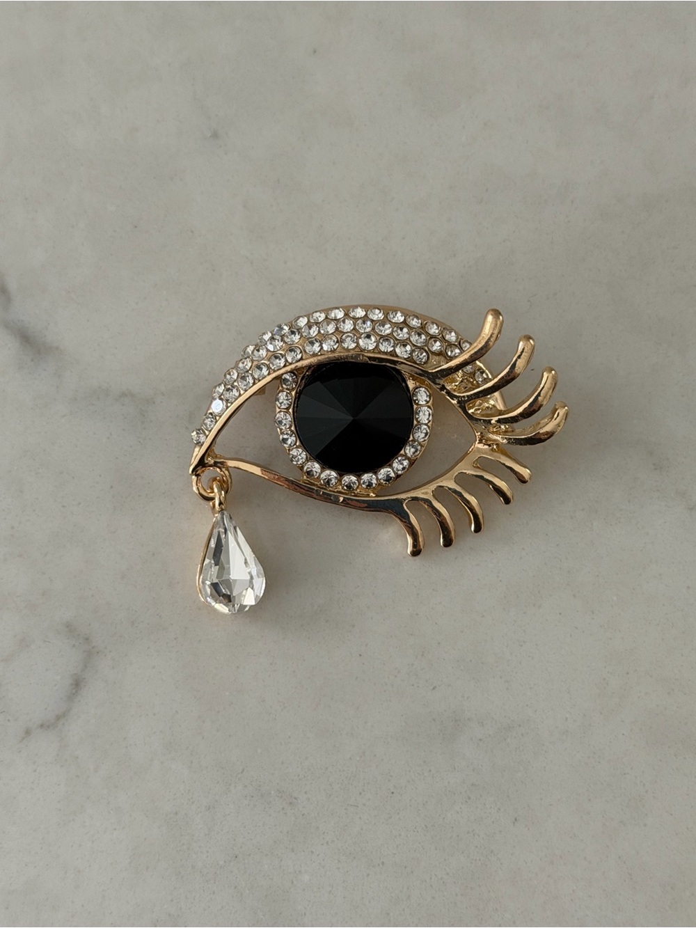 Gold-Tone Black Crystal Eye Brooch with Clear Teardrop